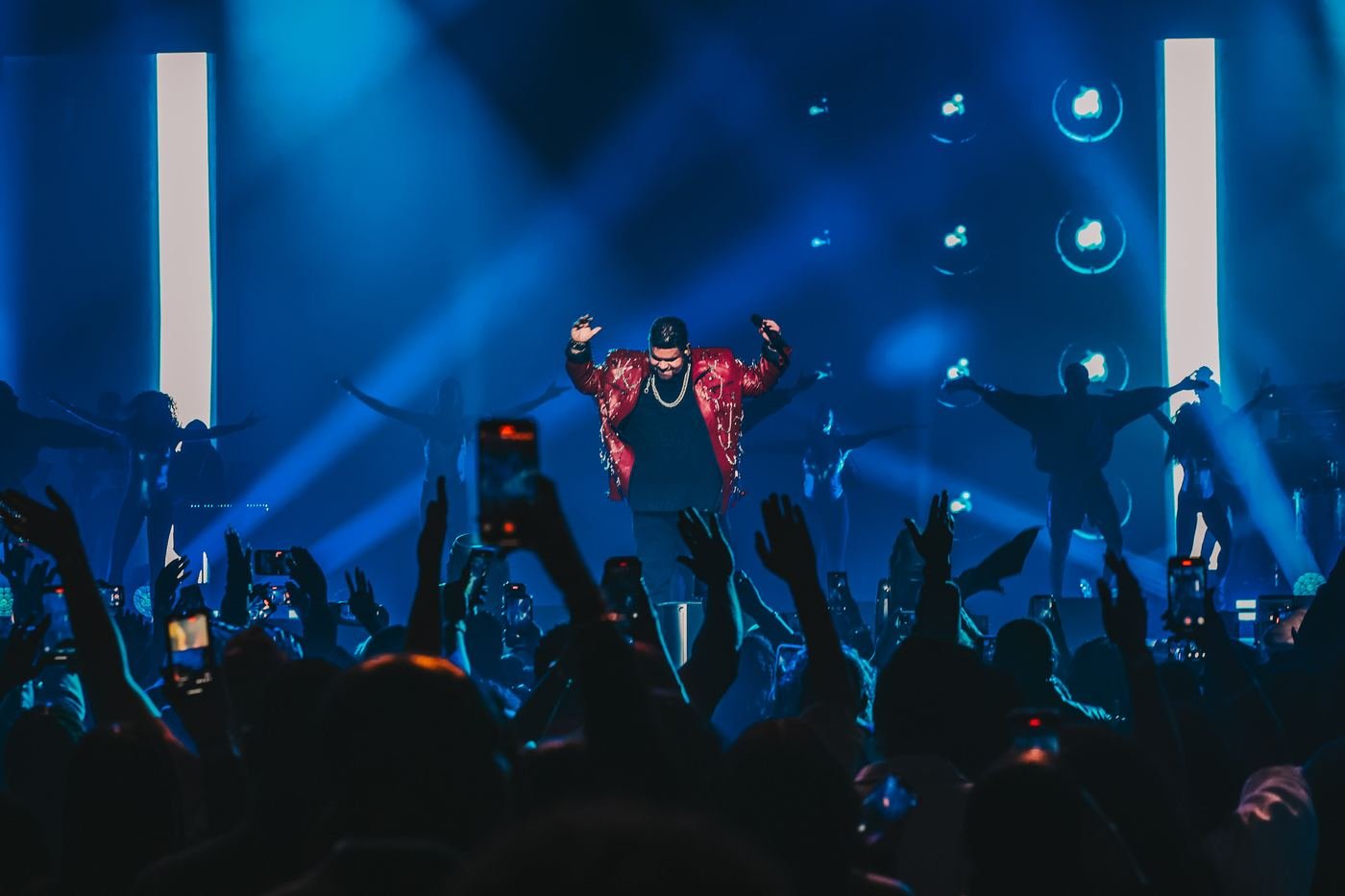 Mickael Guirand greeting the crowd with arms raised on stage