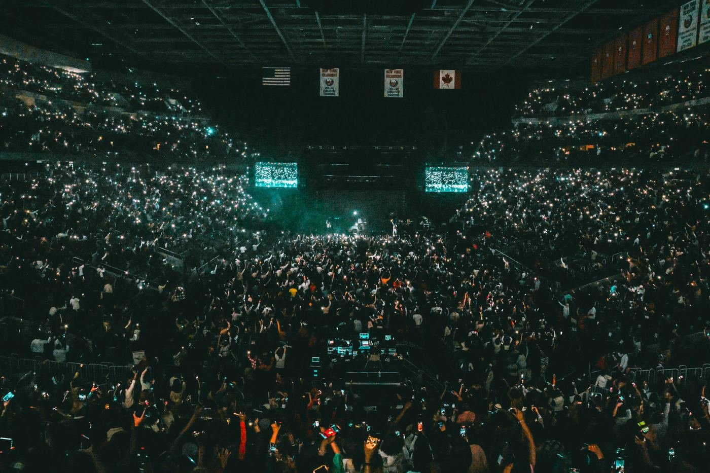 Arena crowd holding up phone lights during the show